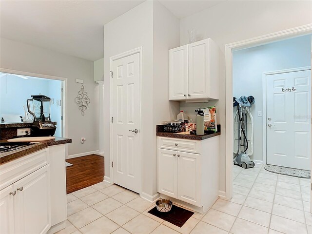 kitchen with light tile patterned floors and white cabinets