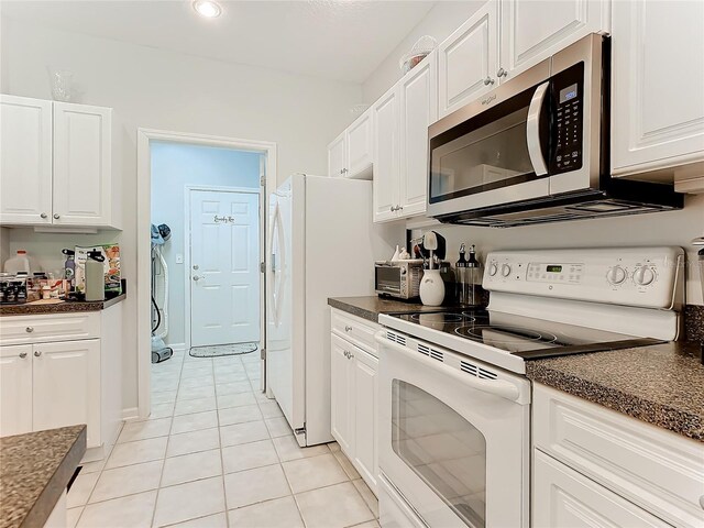 kitchen featuring light tile patterned floors, white appliances, and white cabinets