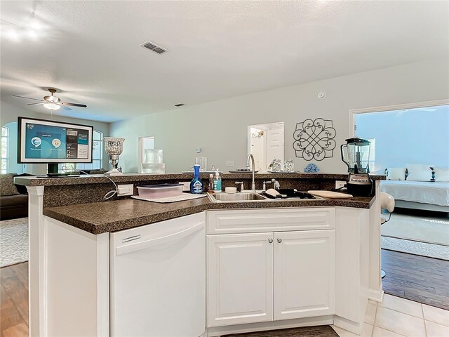 kitchen with sink, light wood-type flooring, white cabinets, white dishwasher, and ceiling fan