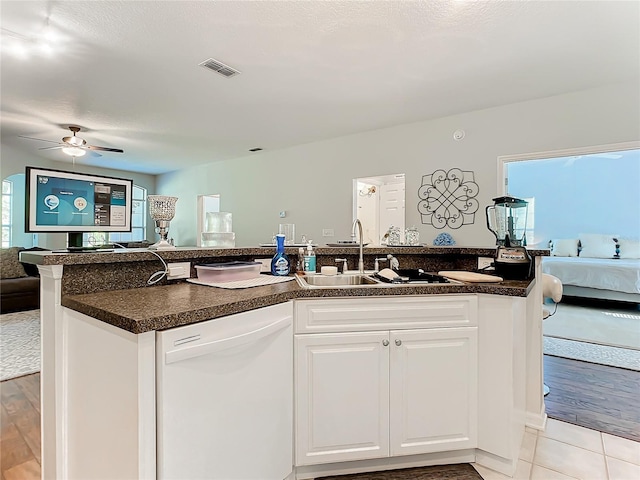 kitchen featuring white dishwasher, visible vents, white cabinetry, open floor plan, and dark countertops