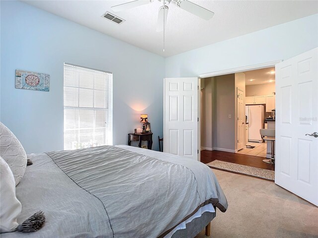 tiled bedroom with ceiling fan and white refrigerator