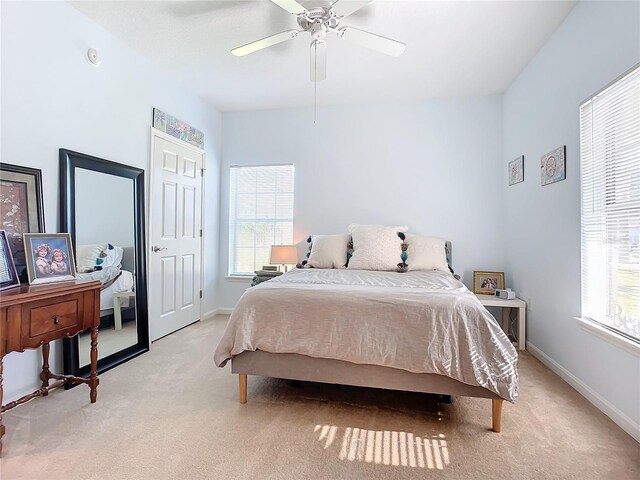 bedroom featuring ceiling fan and light carpet