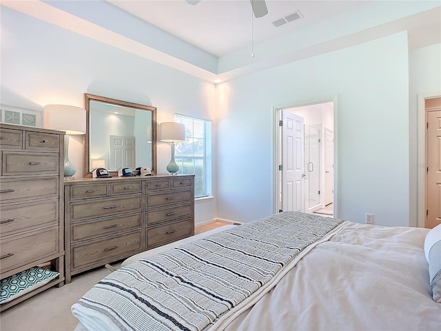 bedroom with light carpet, visible vents, and connected bathroom