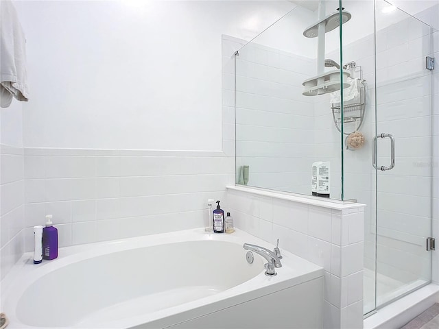 bathroom with a stall shower and a bath