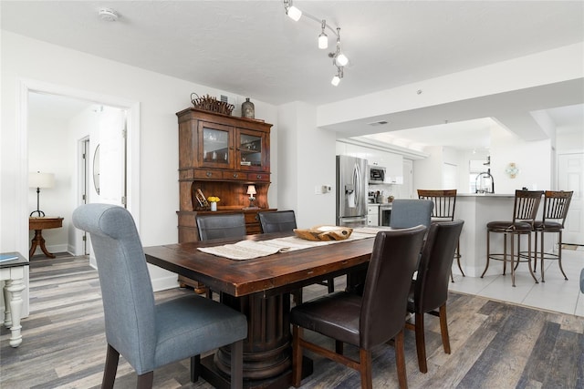 dining area with light wood-style flooring and baseboards