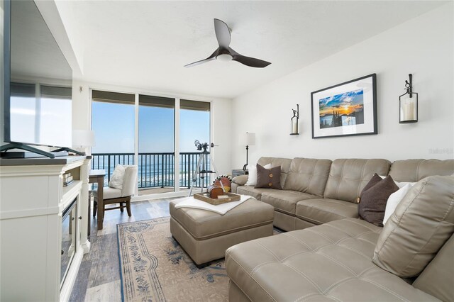 living room with wood finished floors, ceiling fan, and expansive windows