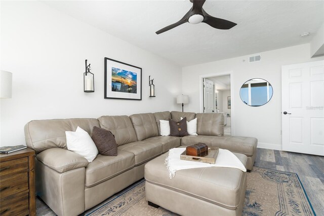 living room featuring visible vents, baseboards, a ceiling fan, and wood finished floors