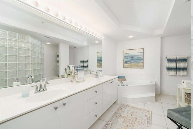 full bathroom featuring a sink, a tray ceiling, a garden tub, and tile patterned floors