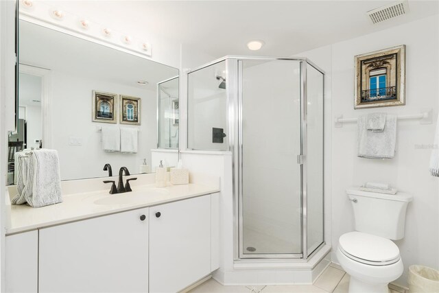 bathroom with visible vents, toilet, a stall shower, and vanity