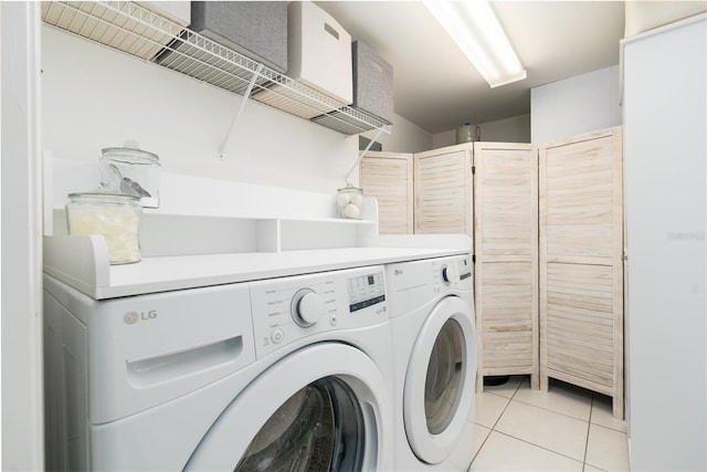 clothes washing area featuring washer and clothes dryer, laundry area, and light tile patterned floors