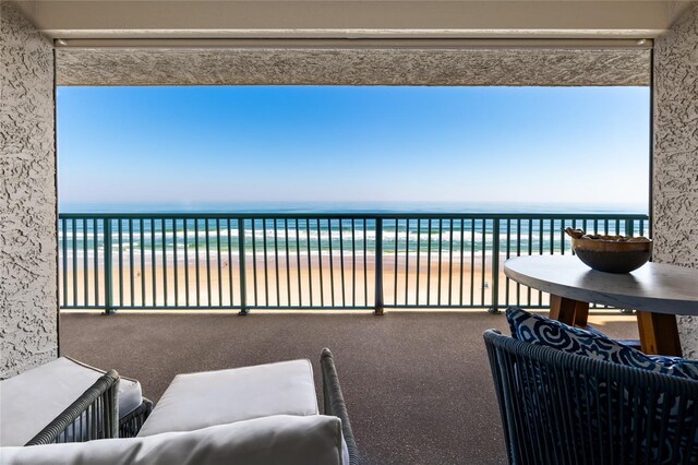 balcony with a beach view and a water view