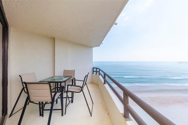 balcony featuring a water view and a view of the beach