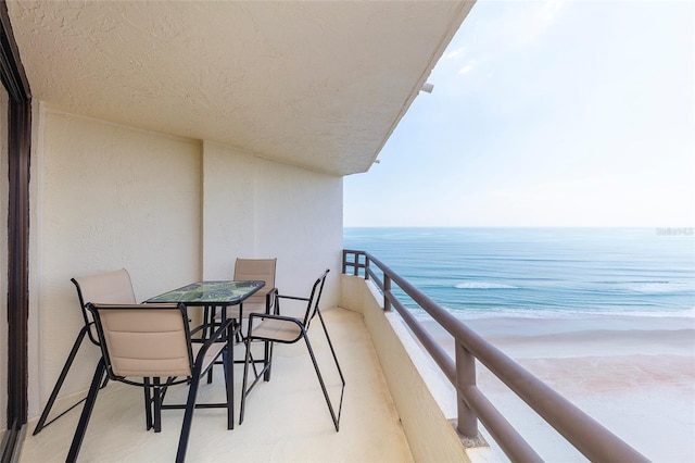 balcony featuring a water view and a beach view