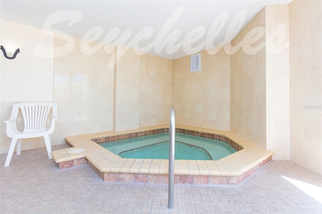 view of swimming pool with an indoor hot tub