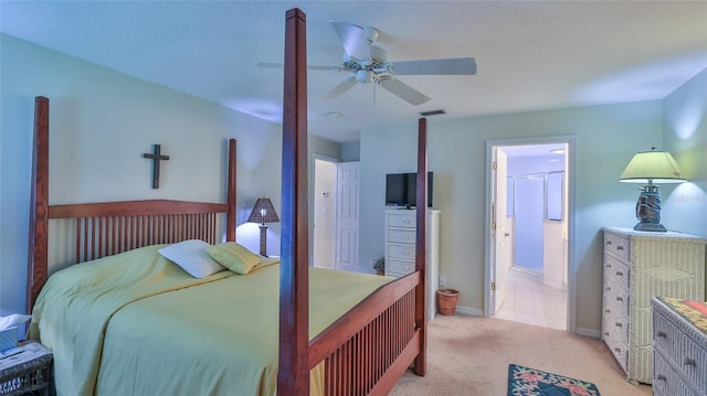 bedroom featuring ceiling fan, connected bathroom, and light colored carpet