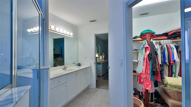 bathroom featuring tile patterned floors, vanity, and walk in shower