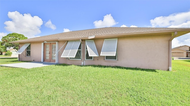 rear view of house featuring french doors and a yard