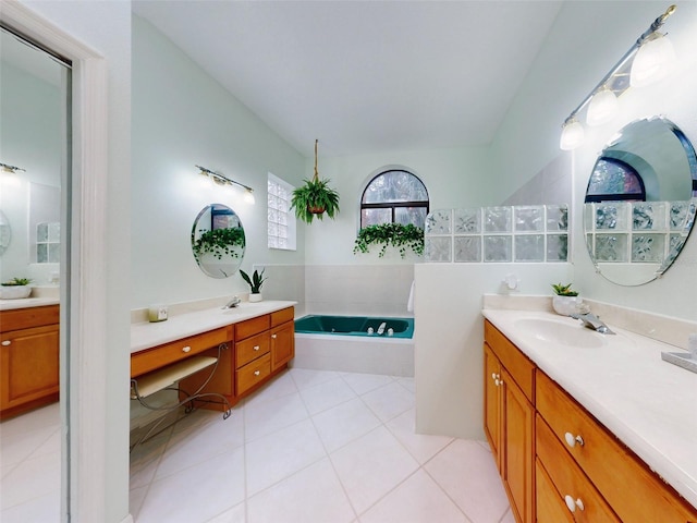 bathroom featuring tile patterned floors, tiled tub, and vanity