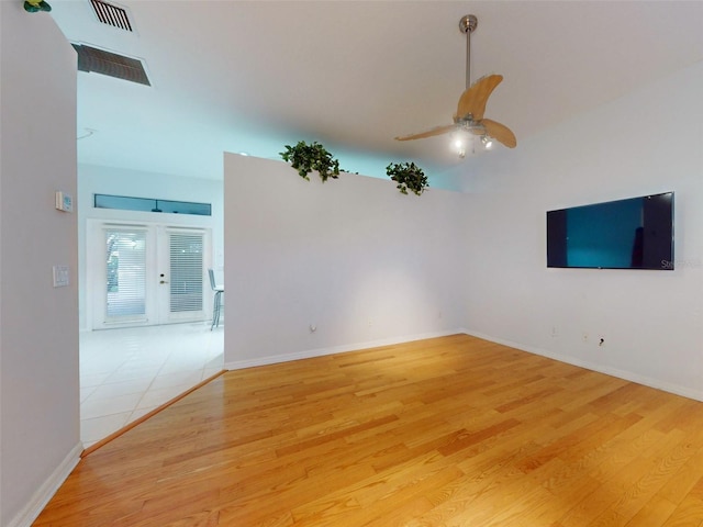 unfurnished living room featuring ceiling fan, light hardwood / wood-style floors, and french doors