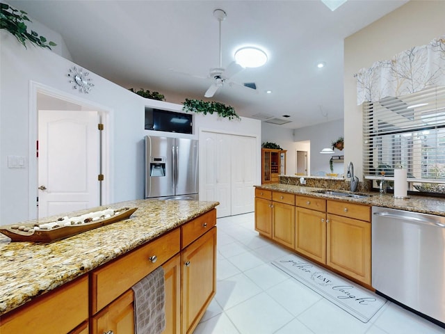 kitchen featuring ceiling fan, sink, light stone counters, light tile patterned floors, and appliances with stainless steel finishes