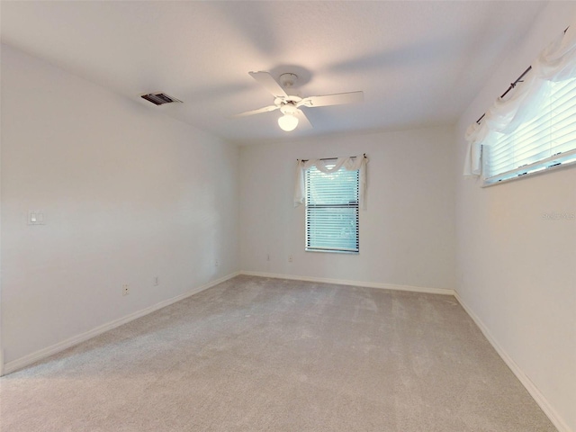 carpeted spare room featuring ceiling fan