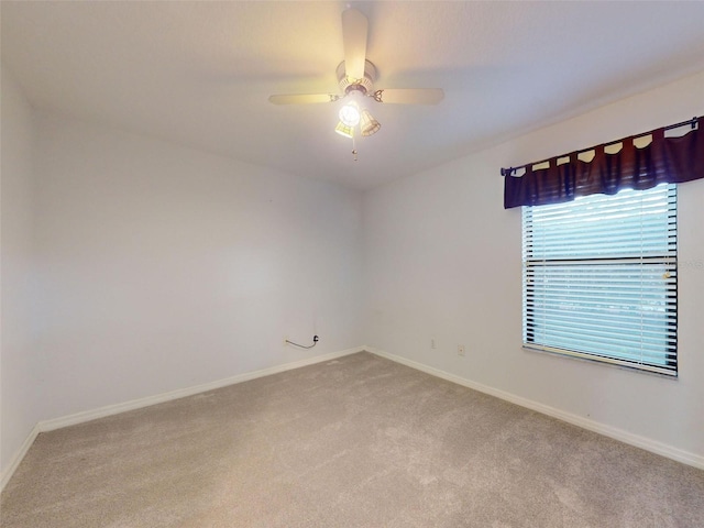 carpeted spare room featuring ceiling fan