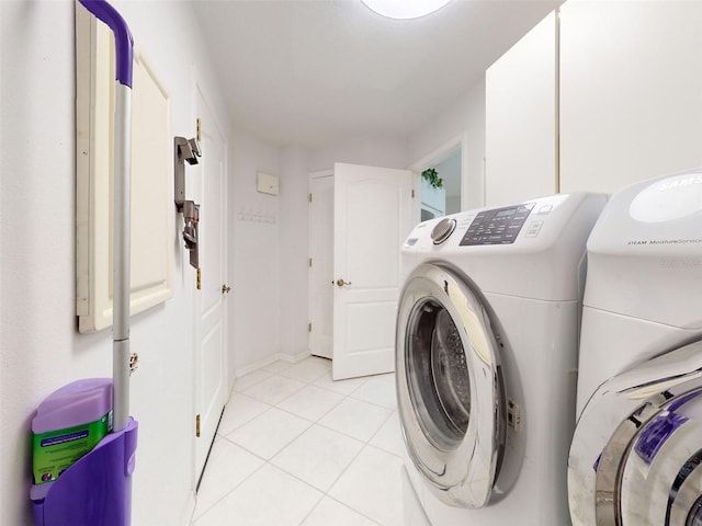 laundry area featuring washing machine and dryer and light tile patterned flooring