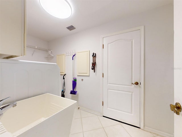 laundry area with light tile patterned floors