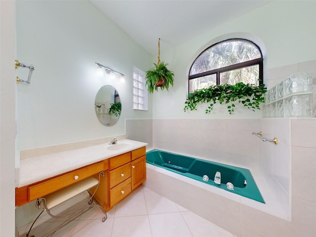 bathroom featuring tile patterned flooring, vanity, and tiled tub