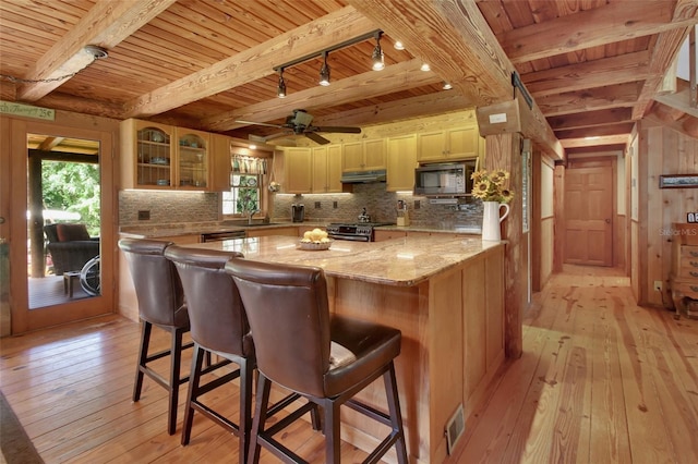 kitchen featuring stainless steel gas range oven, light wood-style floors, wood ceiling, and under cabinet range hood