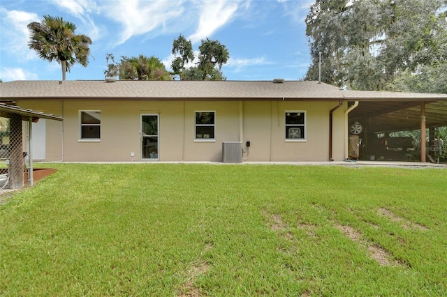 back of house with cooling unit, a yard, and stucco siding