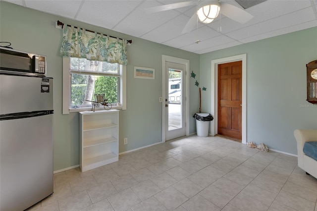 entryway featuring ceiling fan, light tile patterned floors, and baseboards