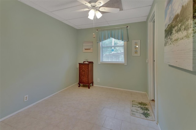 unfurnished room with ceiling fan, a paneled ceiling, and baseboards