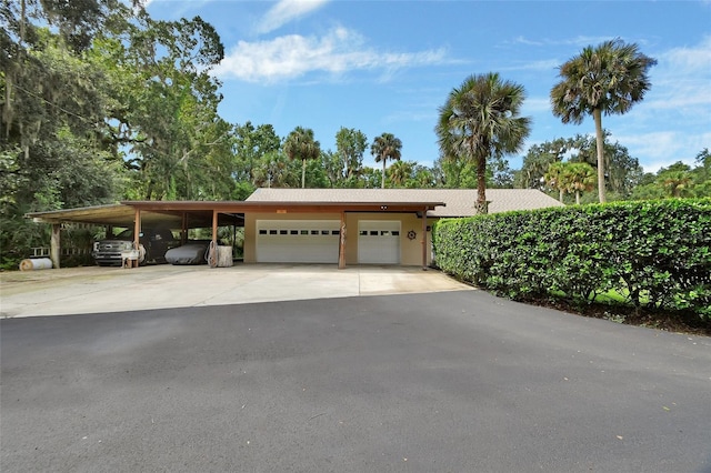 garage with a carport and driveway