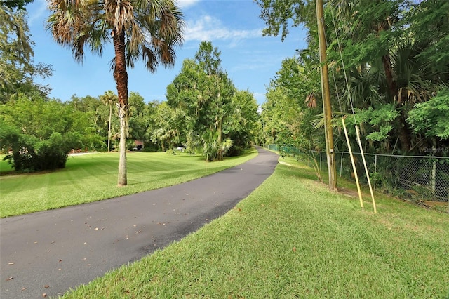 view of property's community featuring fence and a yard