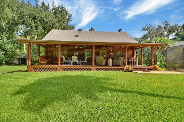 back of house with ceiling fan, log exterior, a yard, and a wooden deck