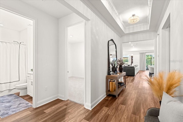 hall with wood-type flooring and crown molding