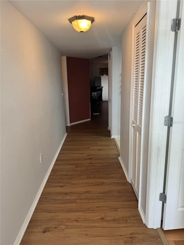 corridor with hardwood / wood-style flooring