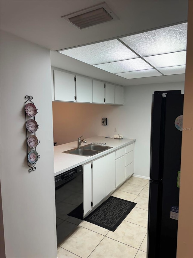 kitchen featuring sink, black appliances, white cabinetry, and light tile patterned flooring