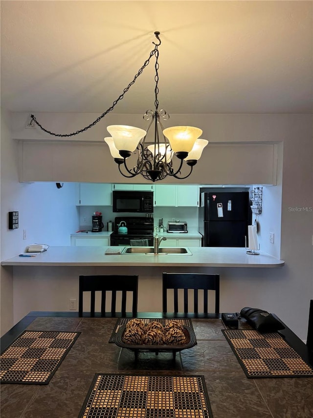 kitchen with sink, tile patterned flooring, black appliances, and a notable chandelier