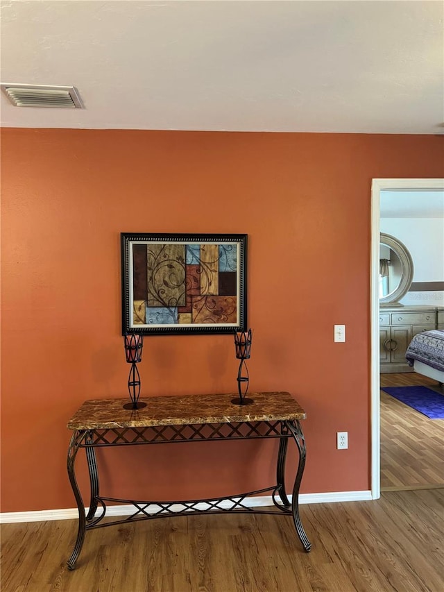 interior space featuring visible vents, baseboards, and wood finished floors