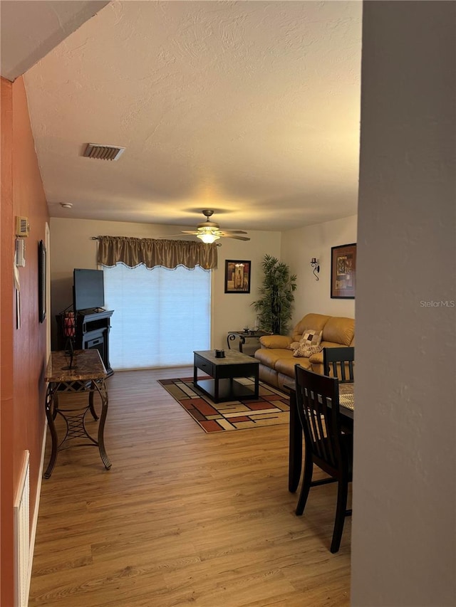 living room with ceiling fan and wood-type flooring