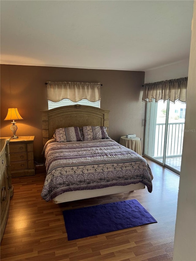 bedroom with access to exterior and hardwood / wood-style floors