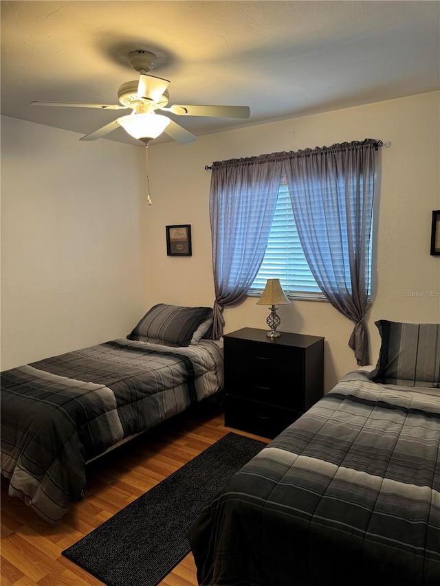 bedroom with ceiling fan and hardwood / wood-style floors