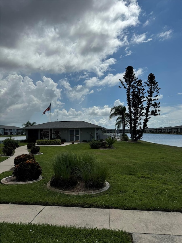 view of front of property featuring a front lawn and a water view