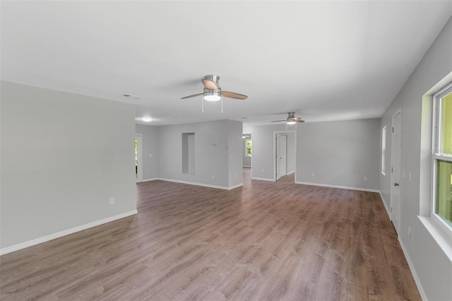 unfurnished room featuring a wealth of natural light, light hardwood / wood-style flooring, and ceiling fan