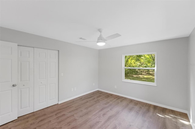 unfurnished bedroom featuring ceiling fan, light hardwood / wood-style flooring, and a closet