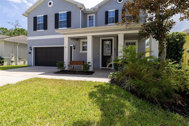 view of front facade with covered porch, a garage, and a front yard