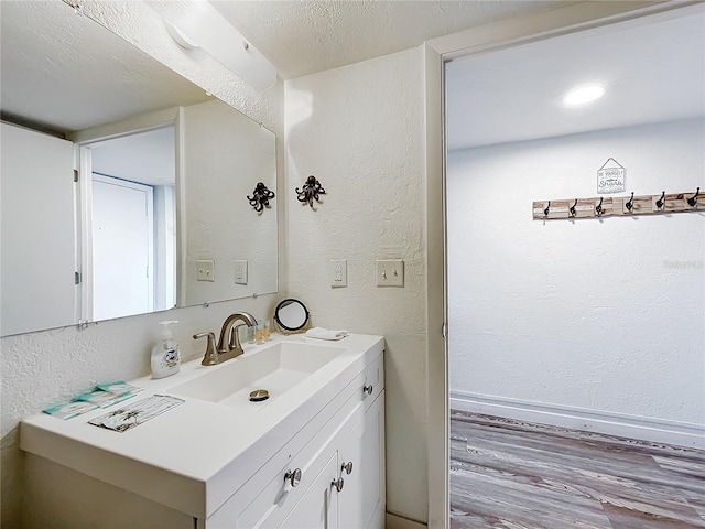 bathroom with vanity, a textured ceiling, and wood-type flooring