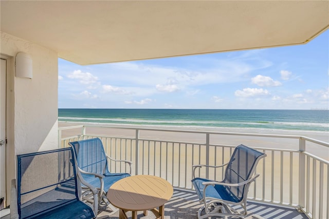 balcony featuring a view of the beach and a water view